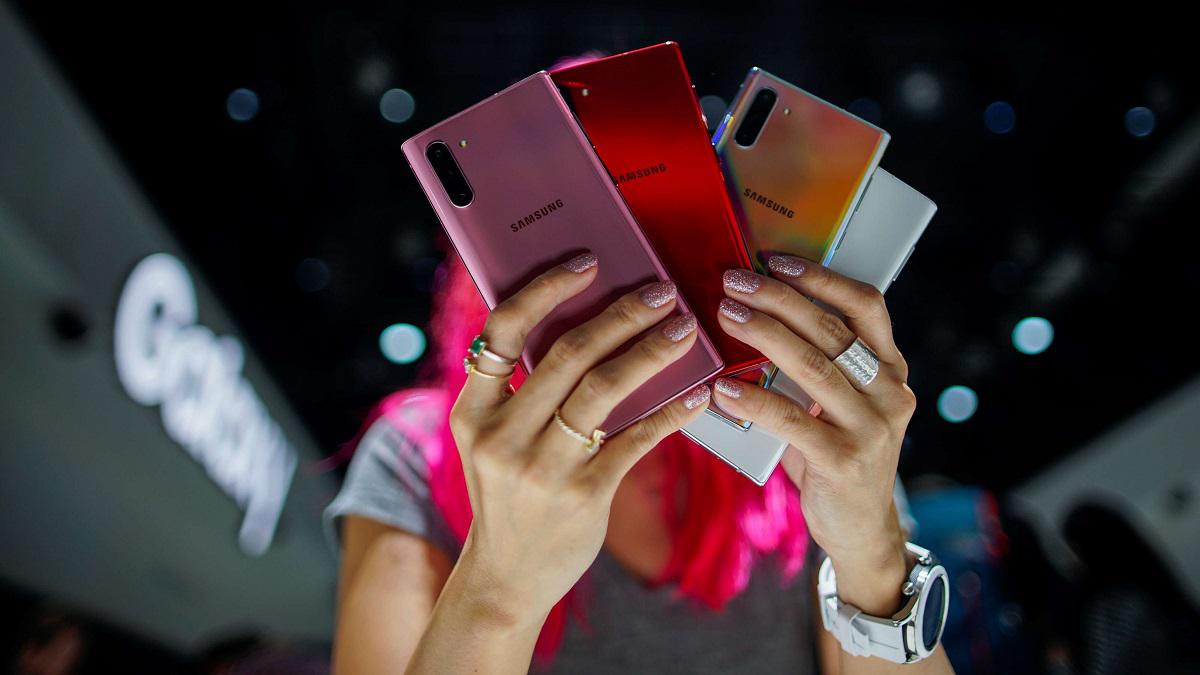 امرأة تحمل نماذج ملونة من هاتف غالاكسي نوت 10