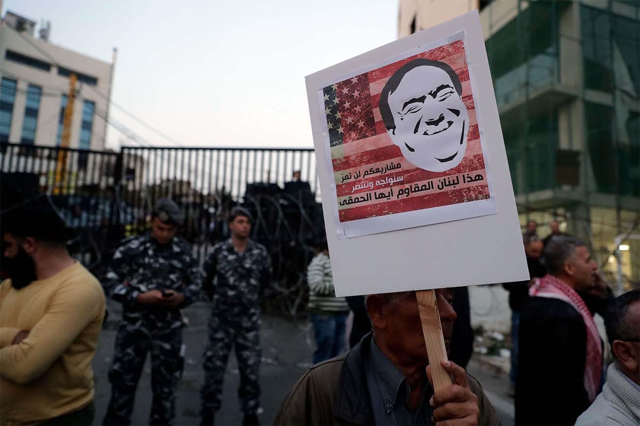 A Lebanese protestor carries a placard bearing a cartoon portrait of US Secretary of State Mike Pompeo during his visit to Beirut last March