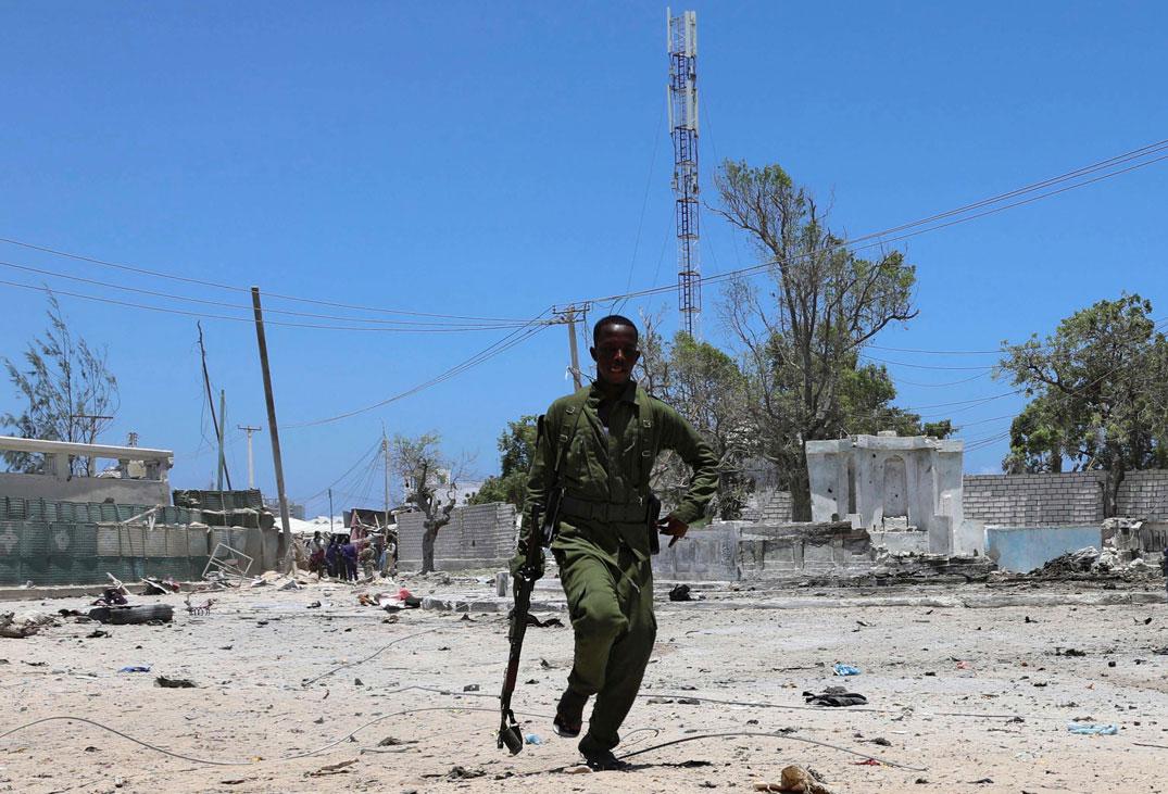 A Somali soldier runs to hold position as al-Shabaab militia storms a government building