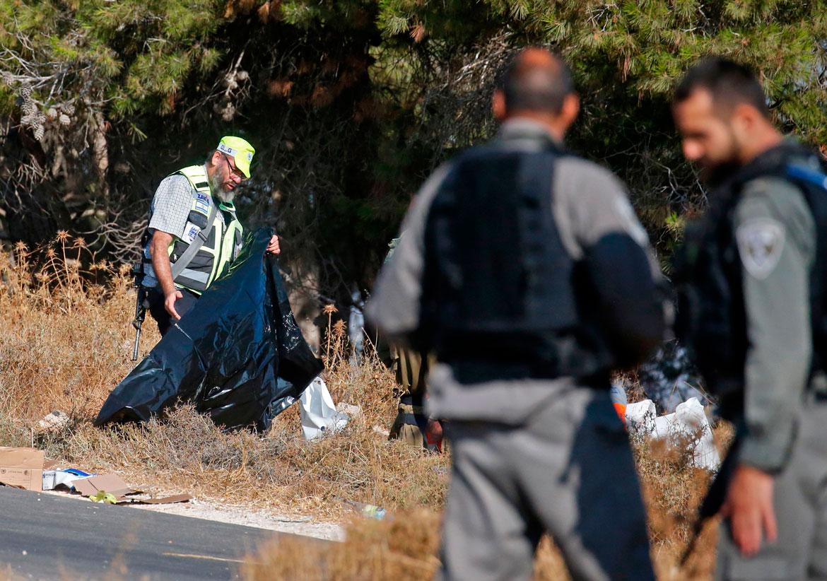 Israeli soldiers and a forensic expert inspect the scene where the body of an Israeli soldier was found with multiple stabs near the settlement of Migdal Oz in the occupied West Bank on August 8, 2019