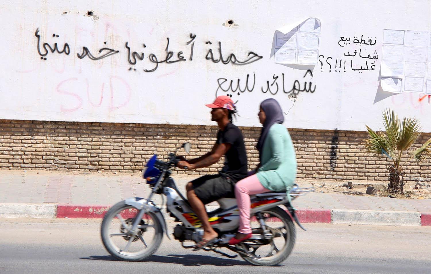تونسيان يمران بالقرب من سياج في مدينة المتلوي