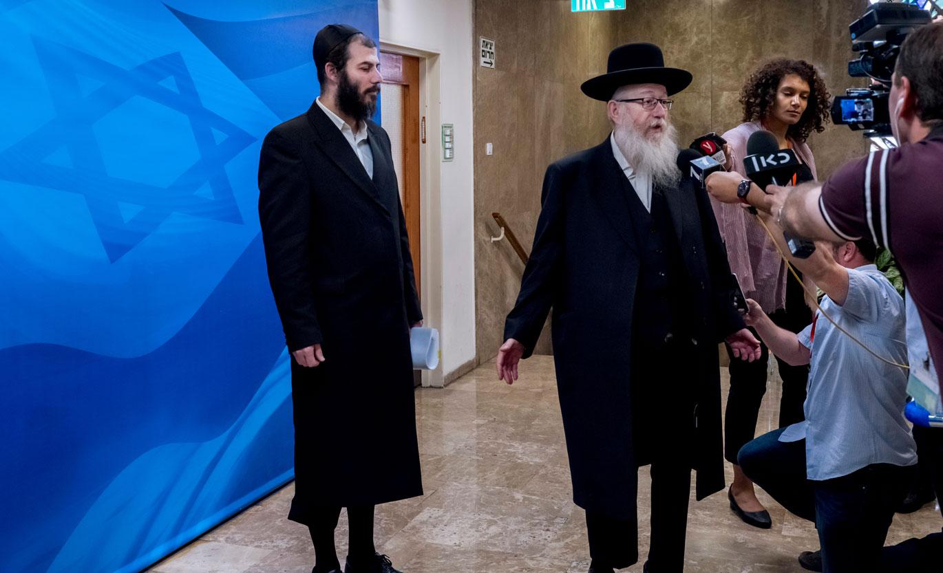 Israeli deputy Health Minister Yaakov Litzman (R) speaks to members of the media