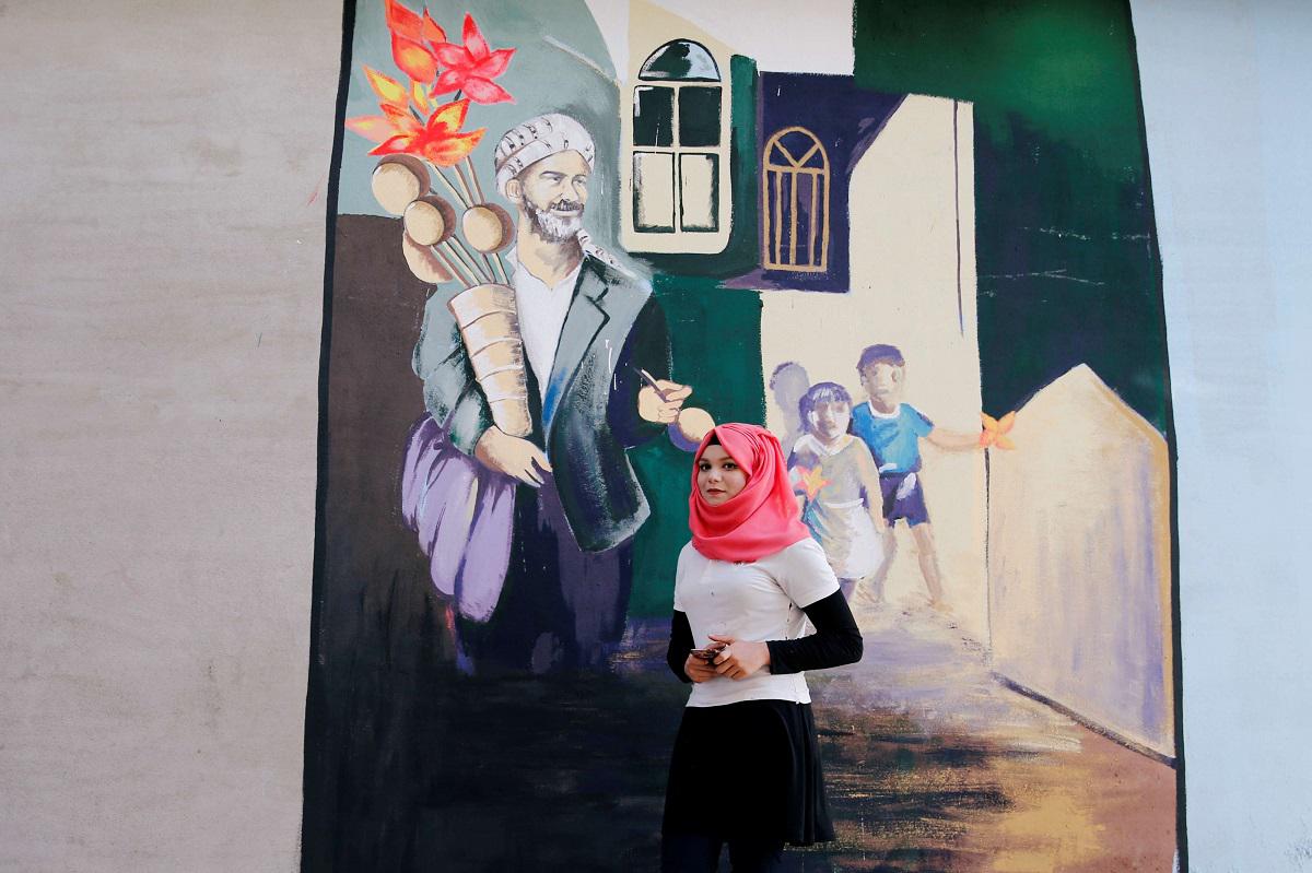 فنانة عراقية أمام جدارية في الموصل