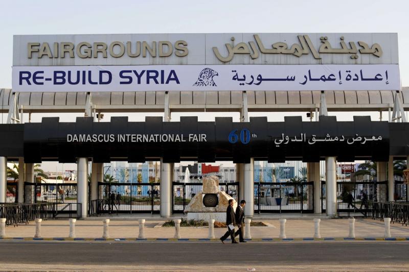 Chinese visitors arrive to the opening of the Syria rebuilding exhibition at the fair grounds in Damascus, Syria