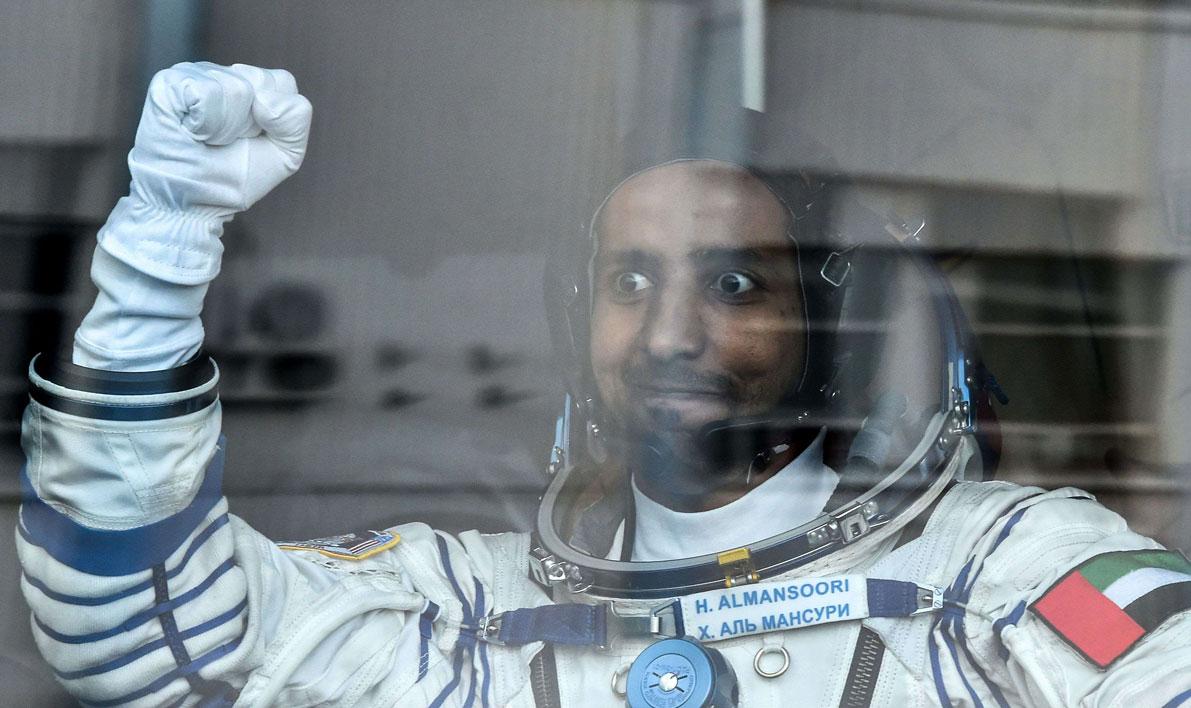 United Arab Emirates' astronaut Hazza Al Mansouri raises his fist from a bus before boarding a Soyuz rocket to the International Space Station