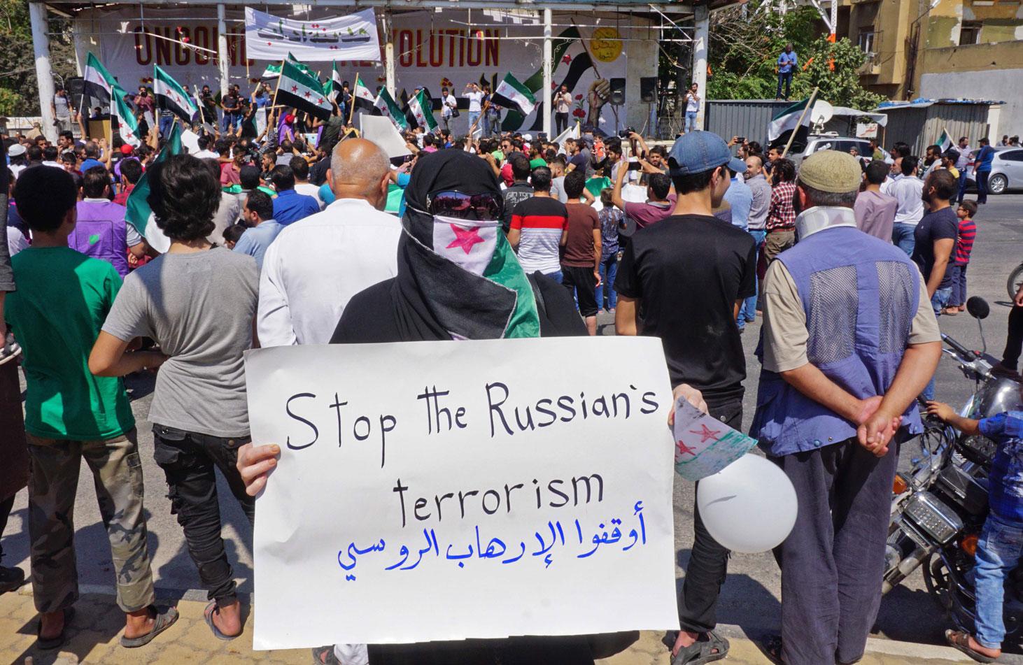 A woman holds up a sign against Russia during a demonstration in Idlib on Sept. 6