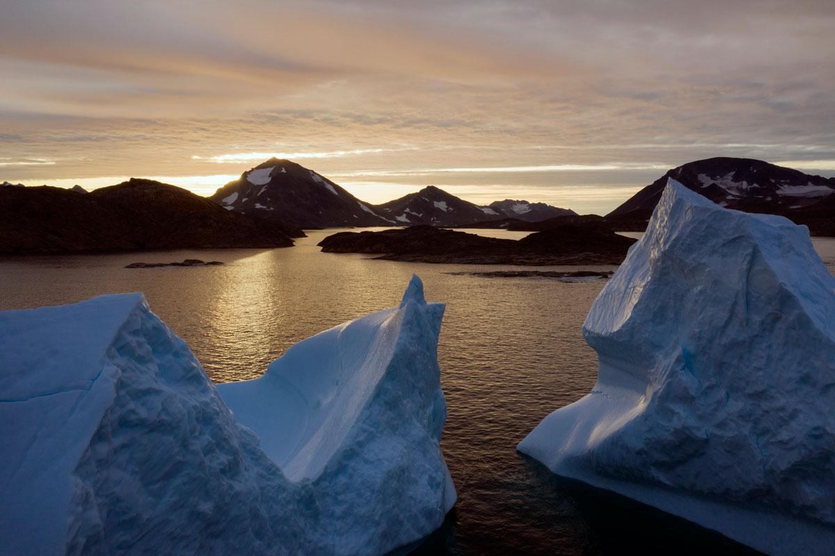 An aerial view of large Icebergs floating as the sun rises near Kulusuk, Greenland