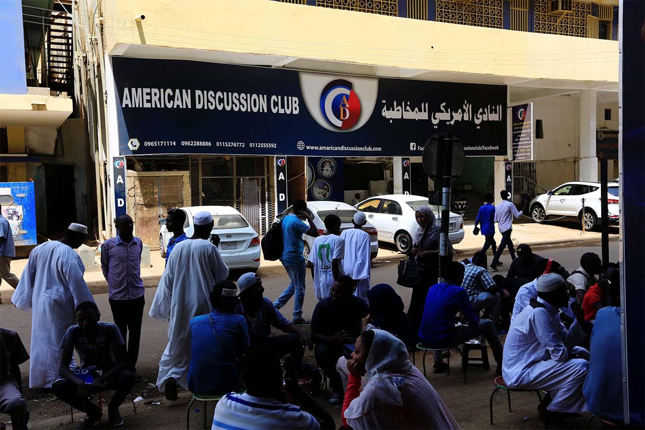 People walk past American Discussion club in Khartoum