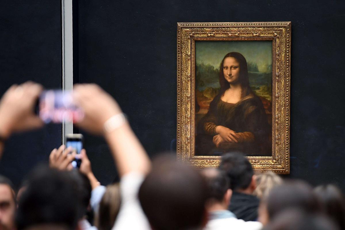 زوار لمتحف اللوفر يلتقطون صورا للوحة الموناليزا