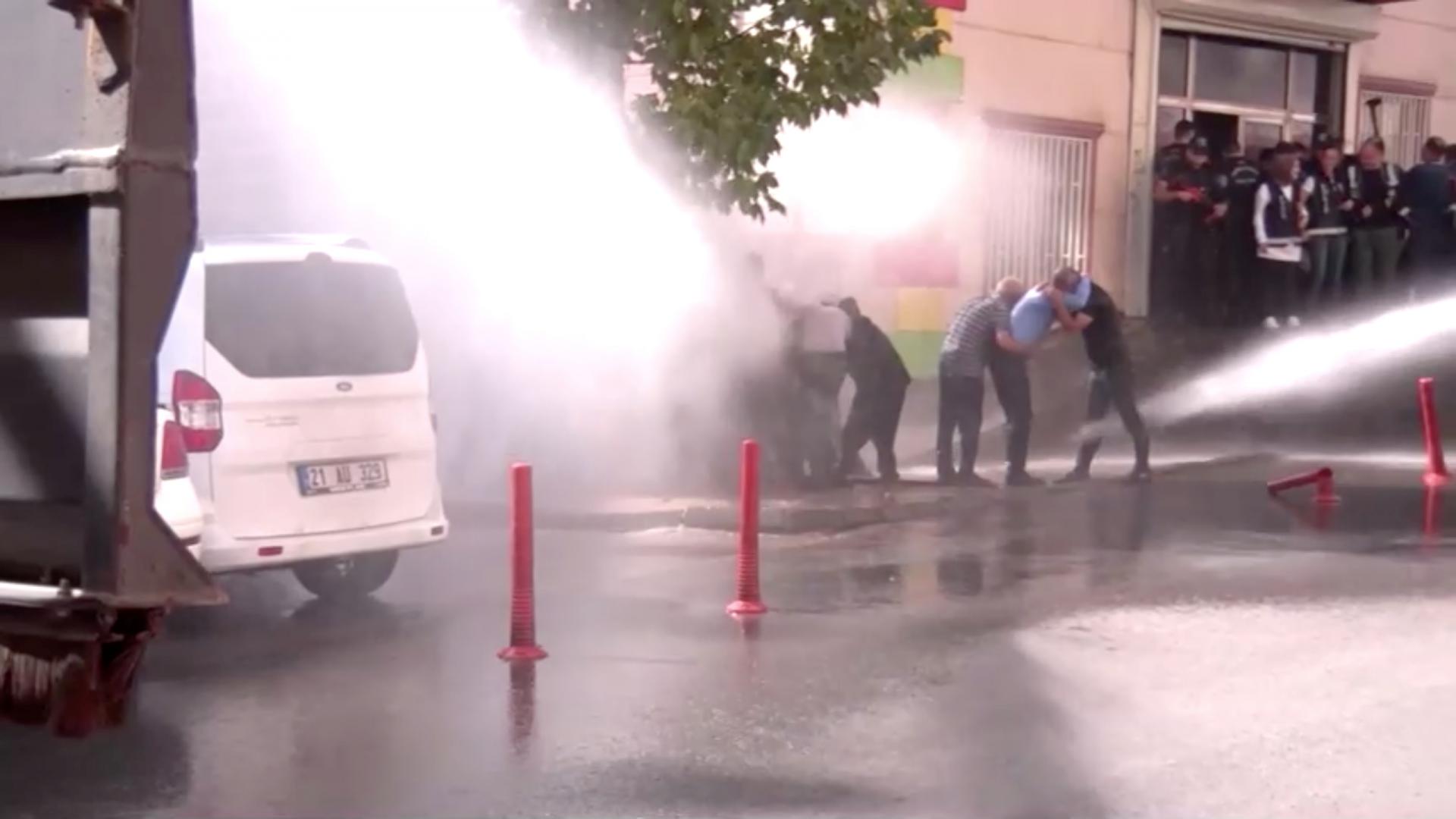 Kurds protesting Turkey's Syria operation are hit by water sprayed from a water cannon in Diyarbakir