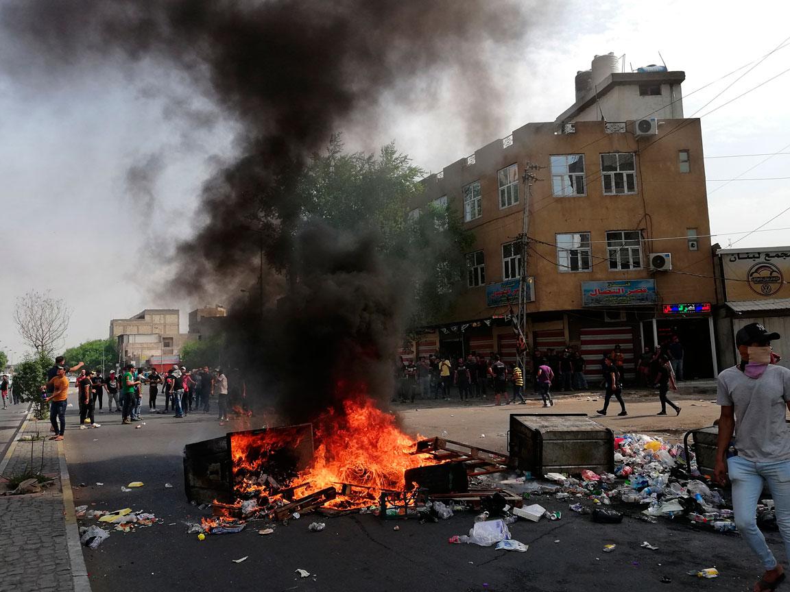 Anti-government protesters set fire and block roads in Baghdad
