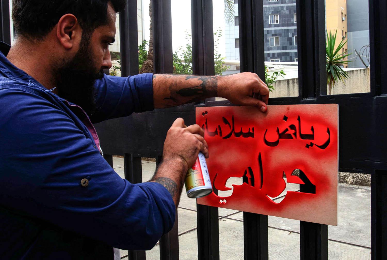 محتج لبناني ينسخ شعارا ضد الفساد