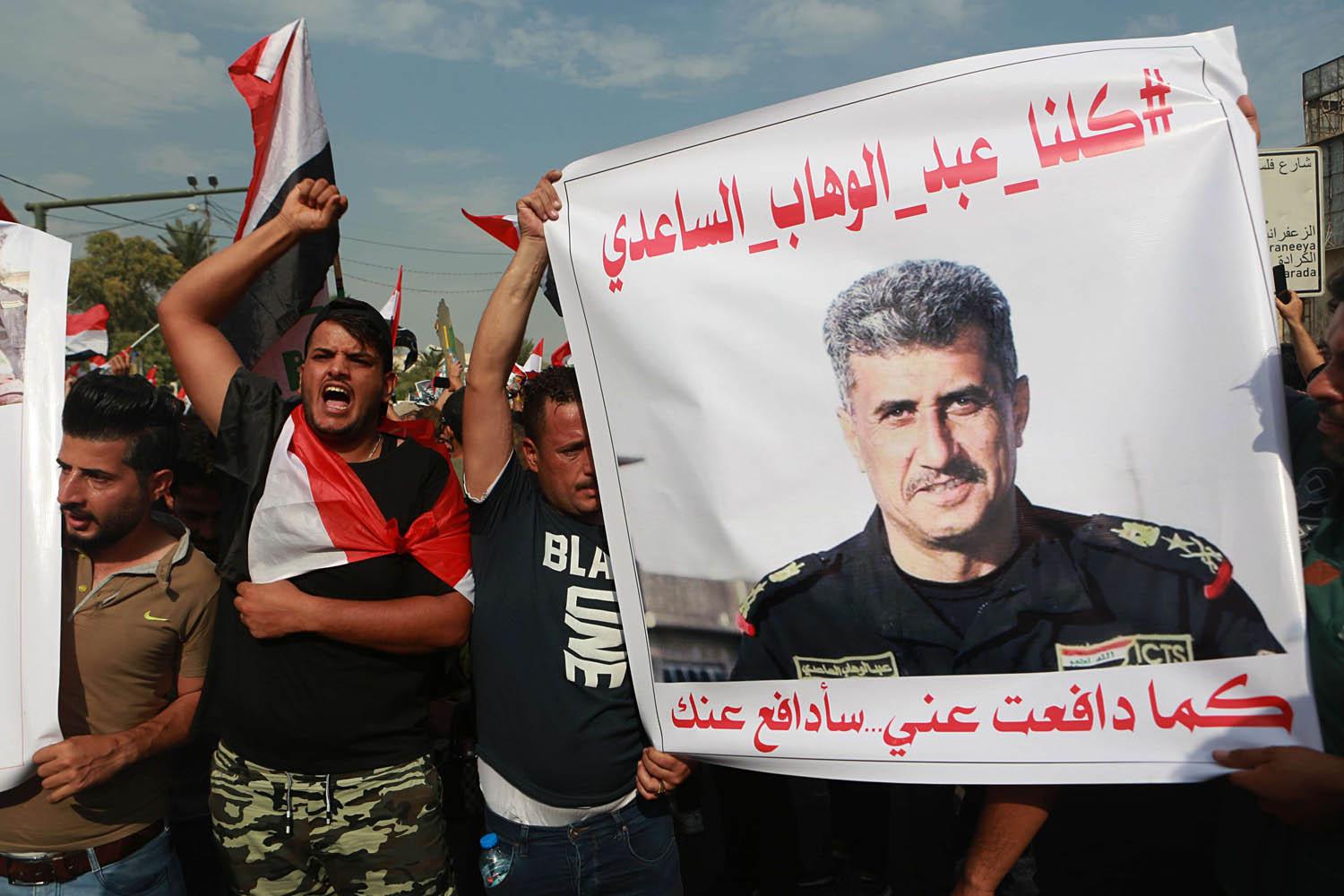 متظاهرون عراقيون يرفعون صورة عبدالوهاب الساعدي