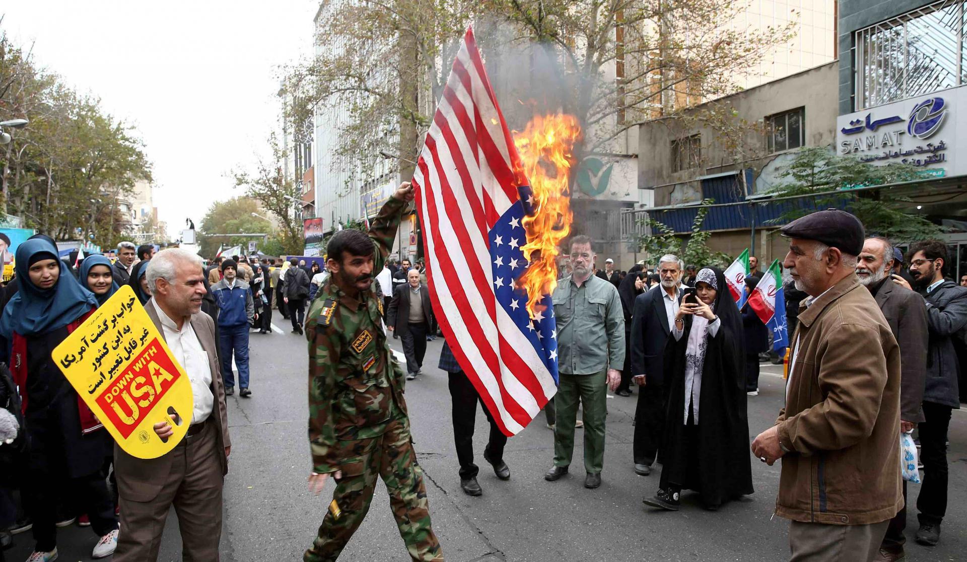 Iranians massed in front of the building carrying placards with slogans such as "Down with USA" and "Death to America."
