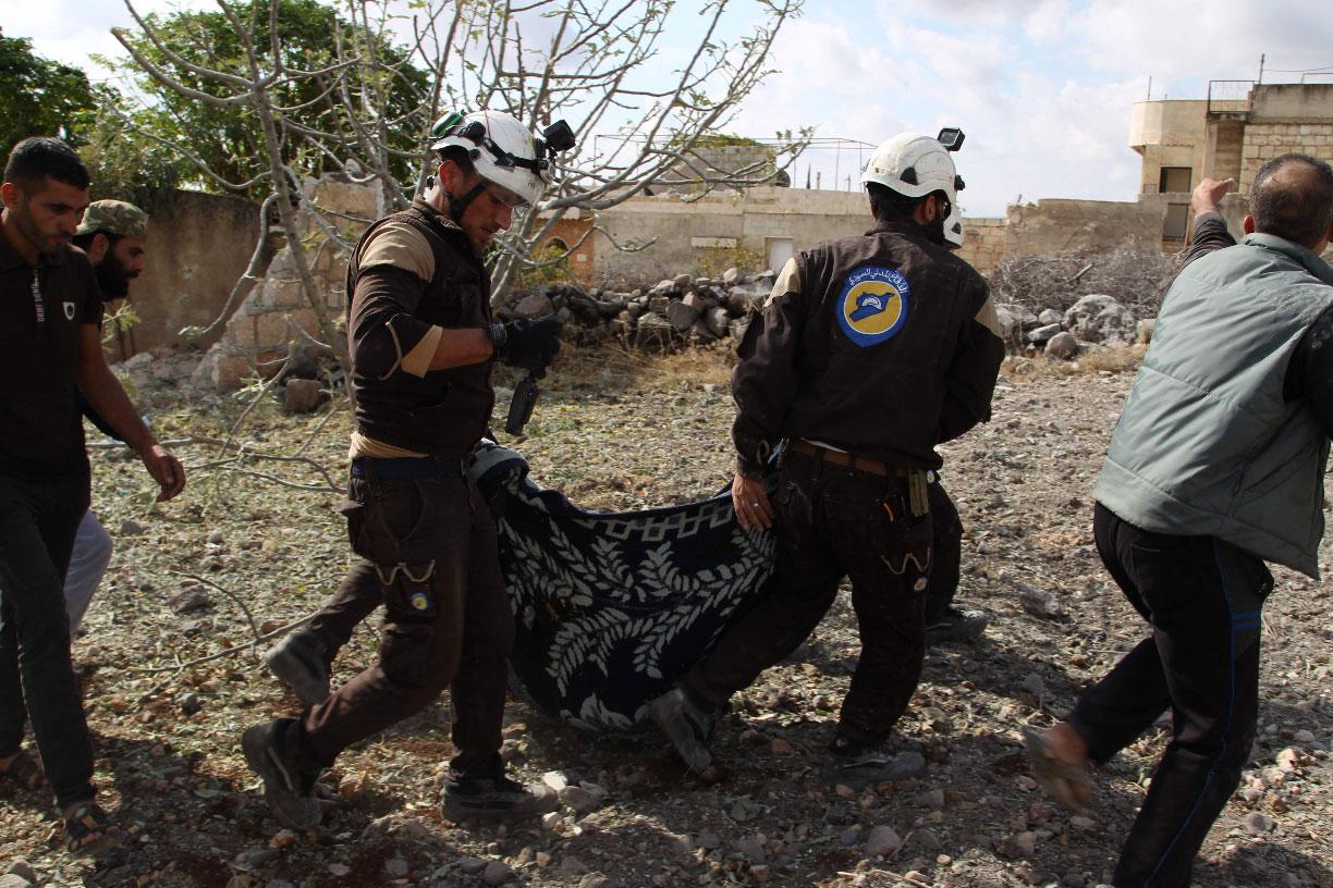 Members of the Syrian Civil Defence (White Helmets) carry away one of the victims of a Russian airstrike that hit the village of Jaballa
