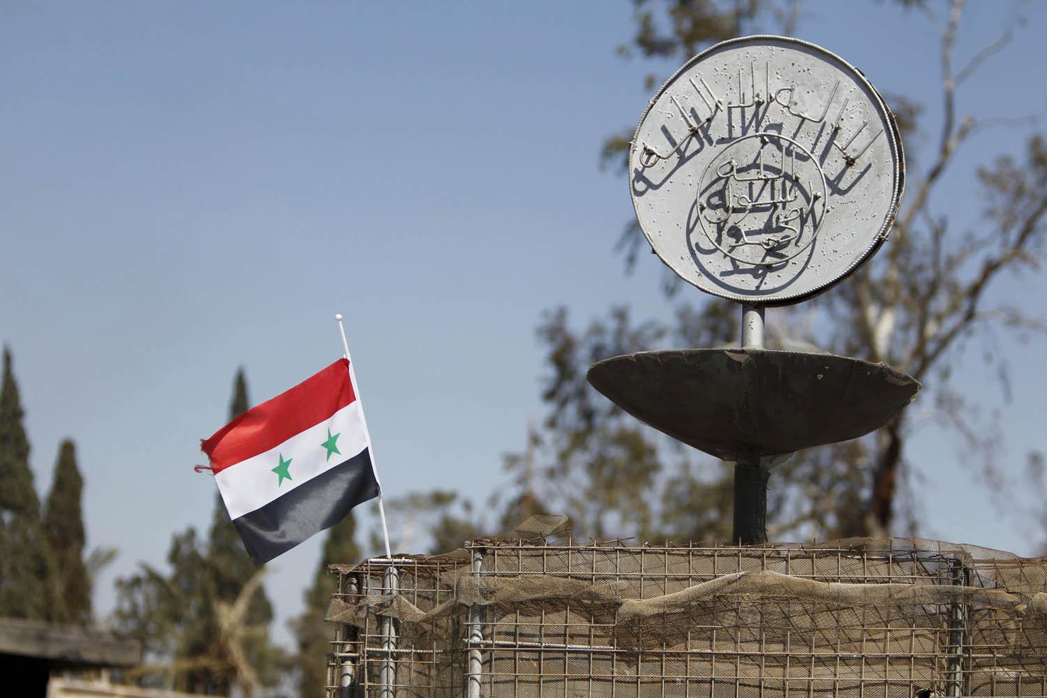 الجيش السوري يرفع علم بلاده بجانب شعار داعش