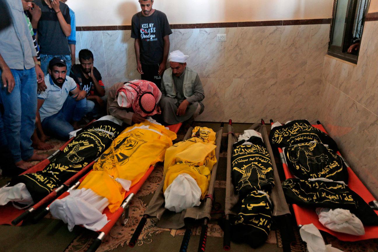 Palestinians mourn over the bodies of members of the same family who were killed overnight in an Israeli airstrike