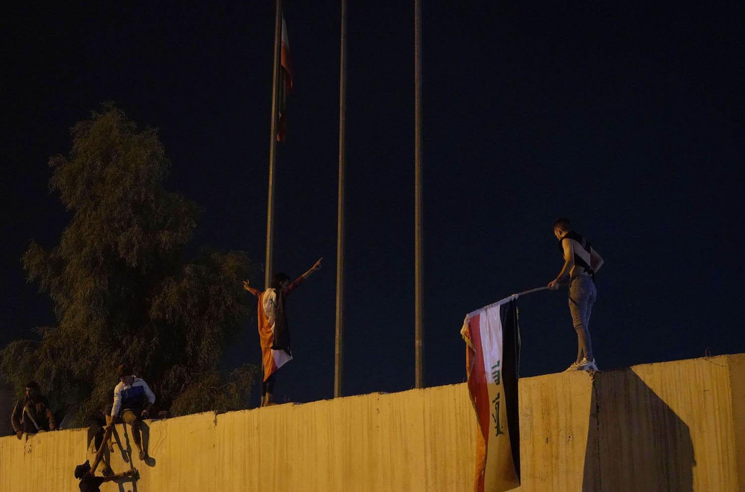 متظاهرون عراقيون يتسلقون اسوار القنصلية الايرانية في كربلاء