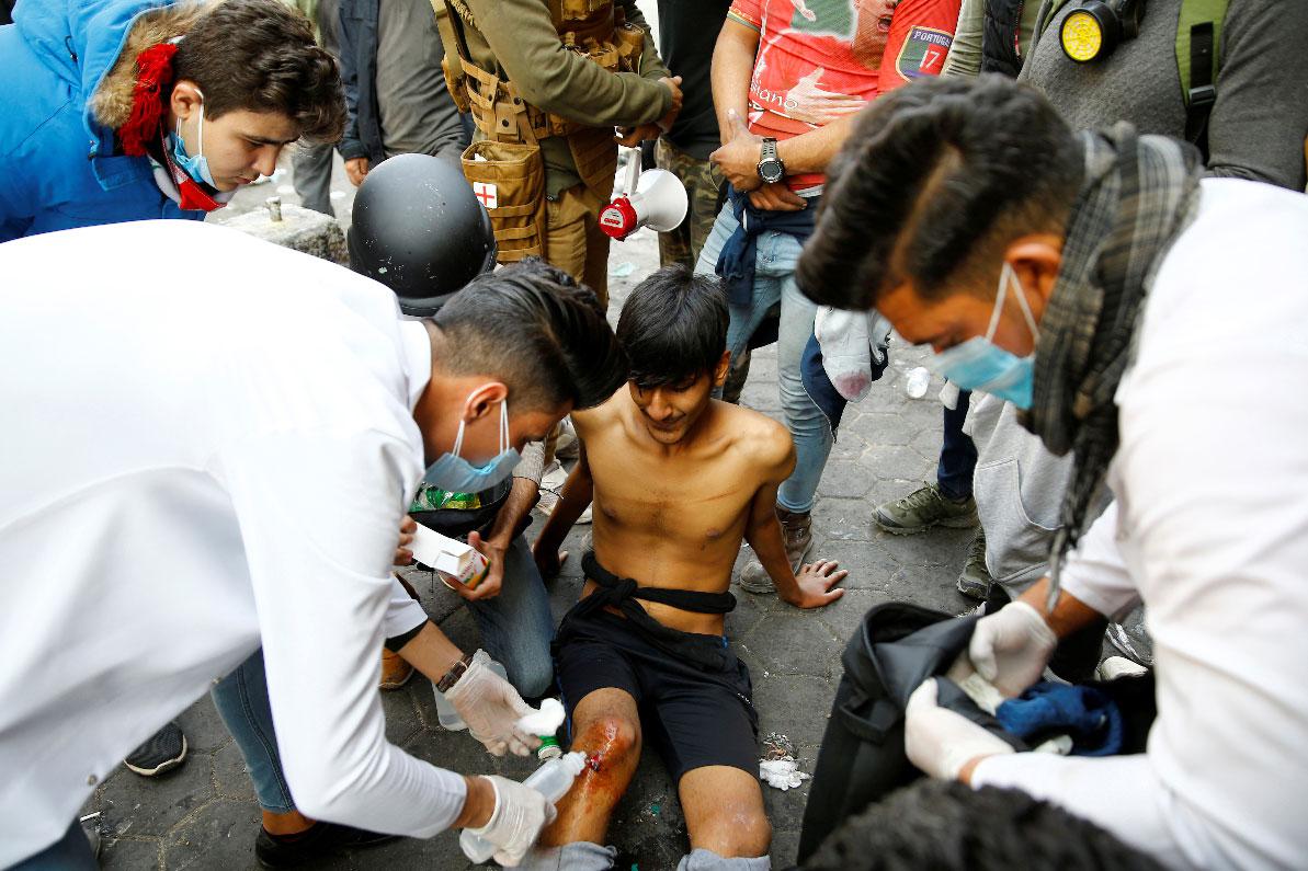 An Iraqi demonstrator receives medical attention during the ongoing anti-government protests