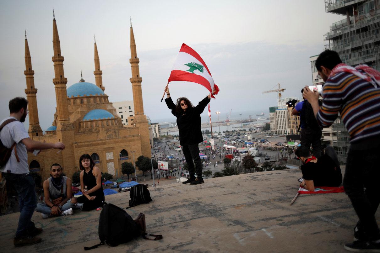 A woman holds a Lebanese flag