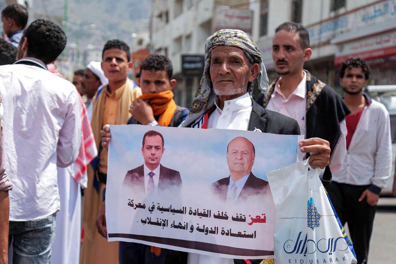 يمني يرفع صورة للرئيس ورئيس الوزراء في تعز