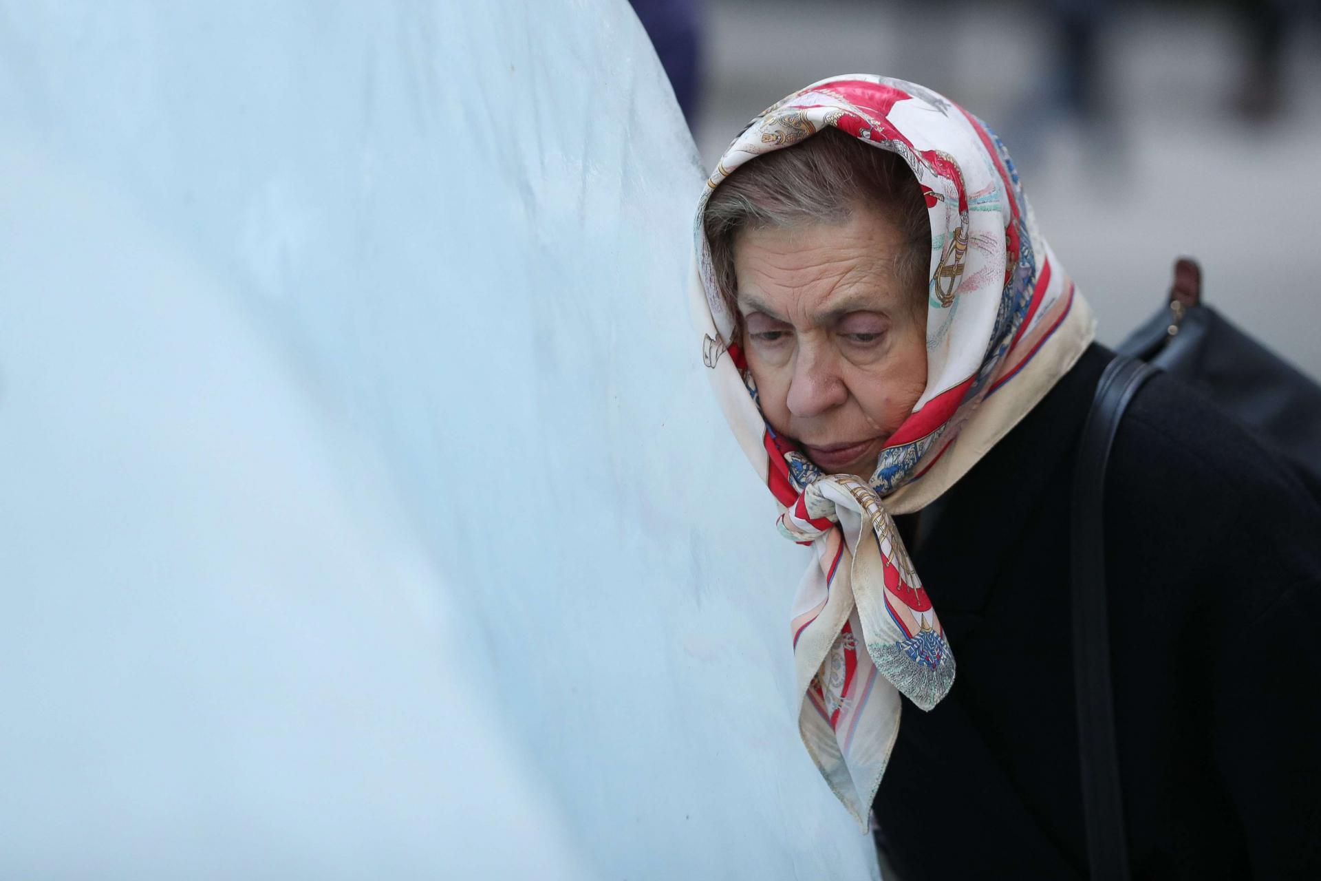 امرأة تضع رأسها على كتلة جليد خلال معرض فني بلندن للتوعية بآثار التغير المناخي
