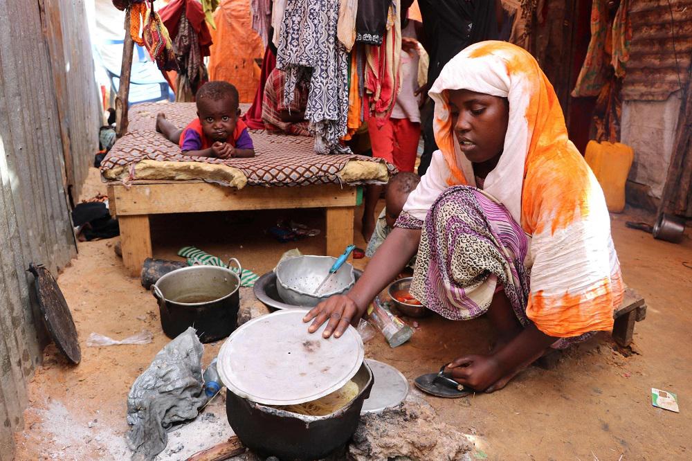 أم صومالية تطبخ لعائلتها وجبة متواضعة على النار