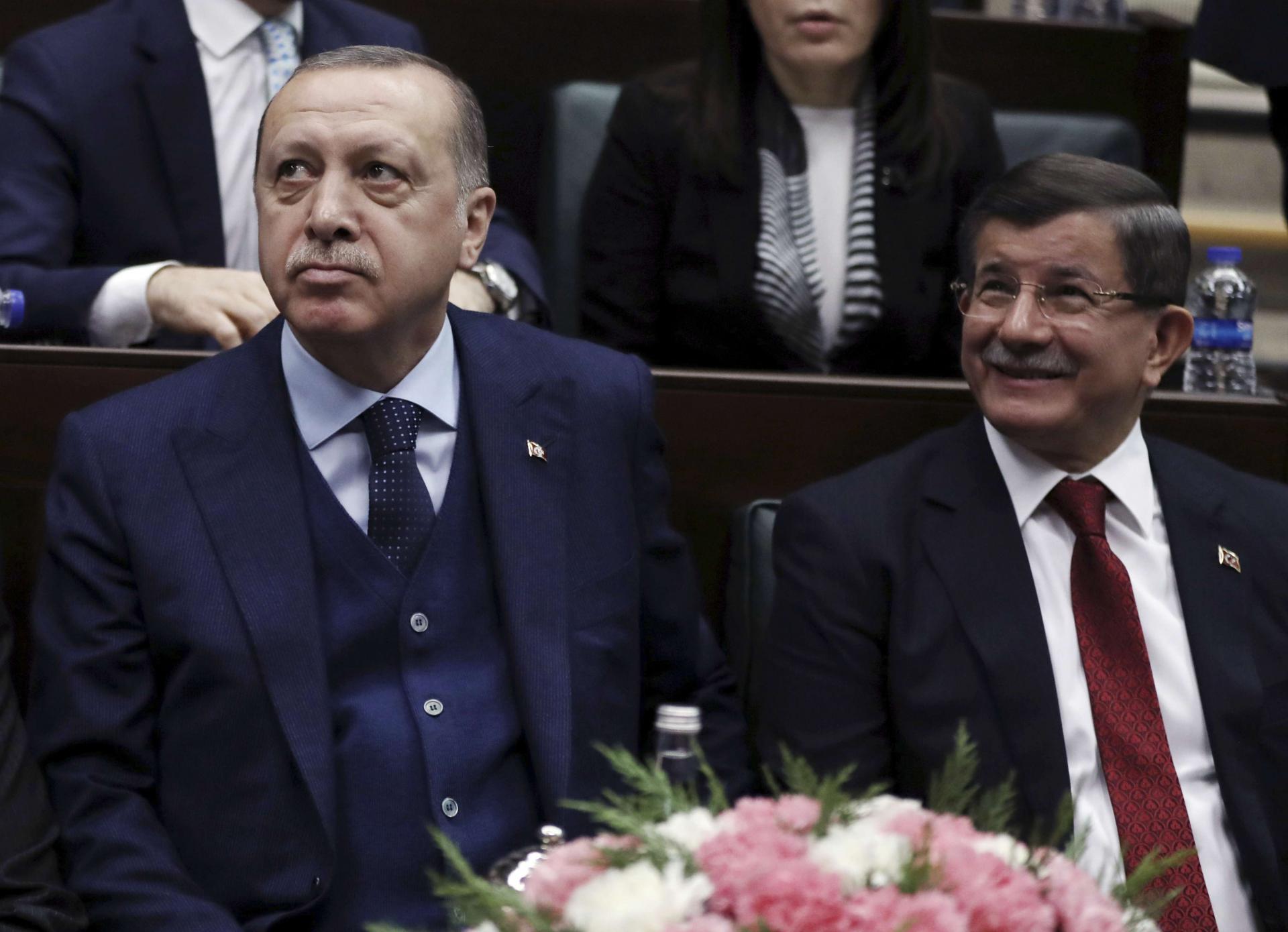 أحمد داوود أوغلو (يمين) يجلس إلى جانب أردوغان