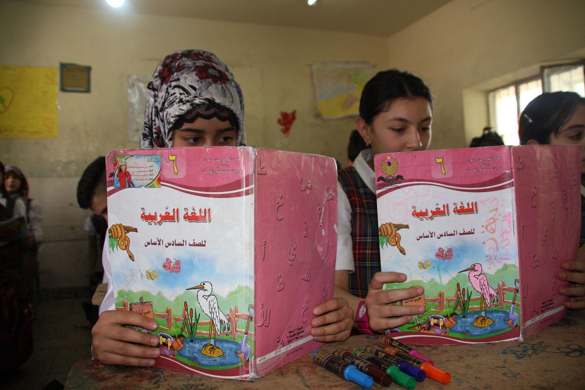 طالبات عراقيات يقرأن من كتاب اللغة العربية