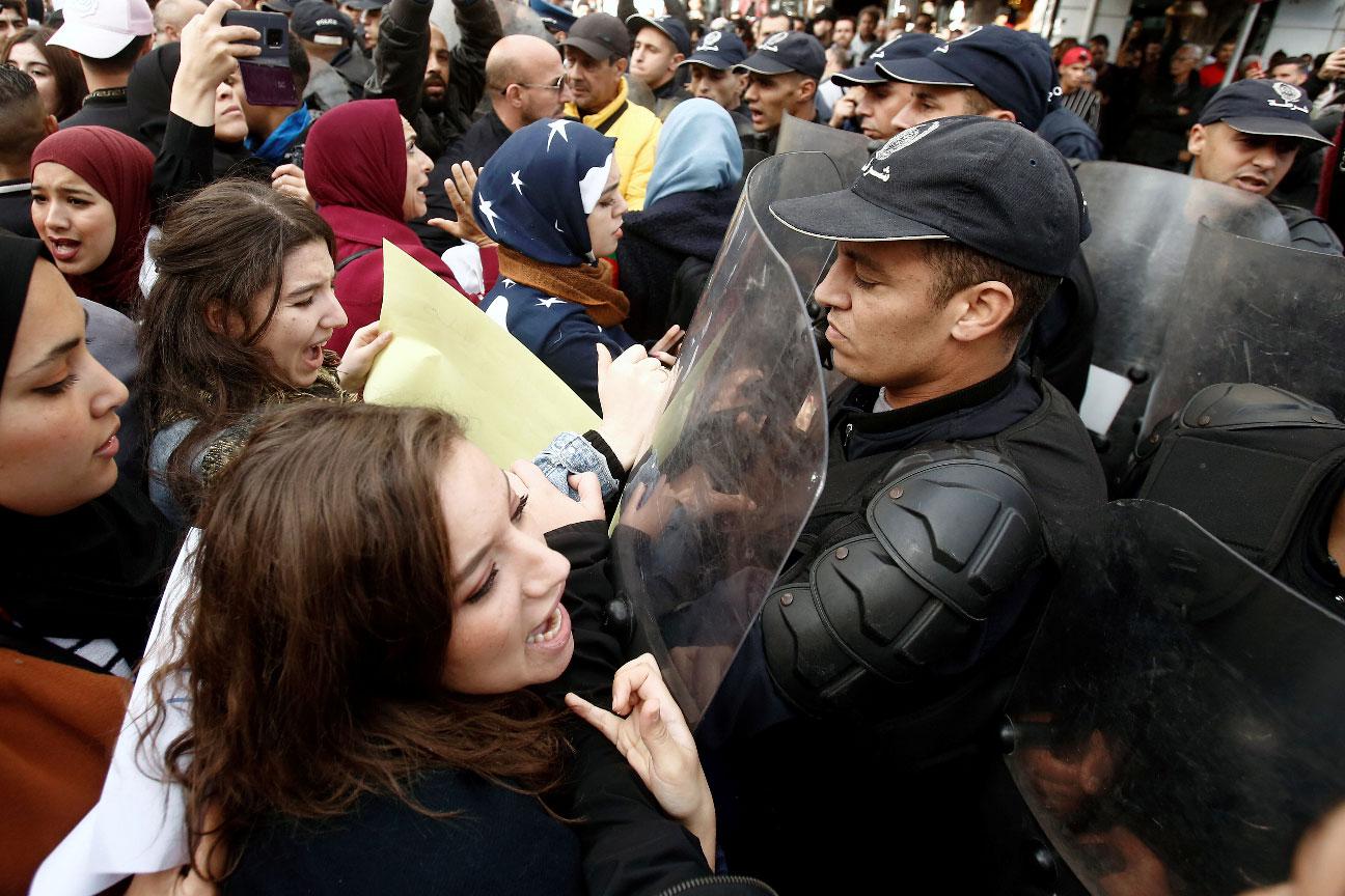 Police officers try to disperse demonstrators during a protest rejecting upcoming presidential election in Algiers