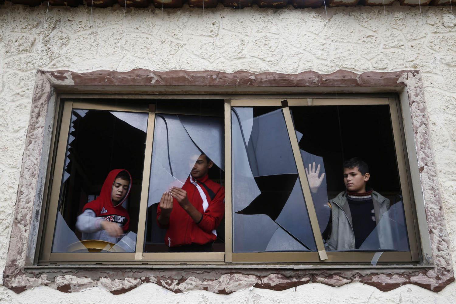 فلسطينيون في غزة يزيلون زجاج نوافذ محطم بعد غارة اسرائيلية قريبة