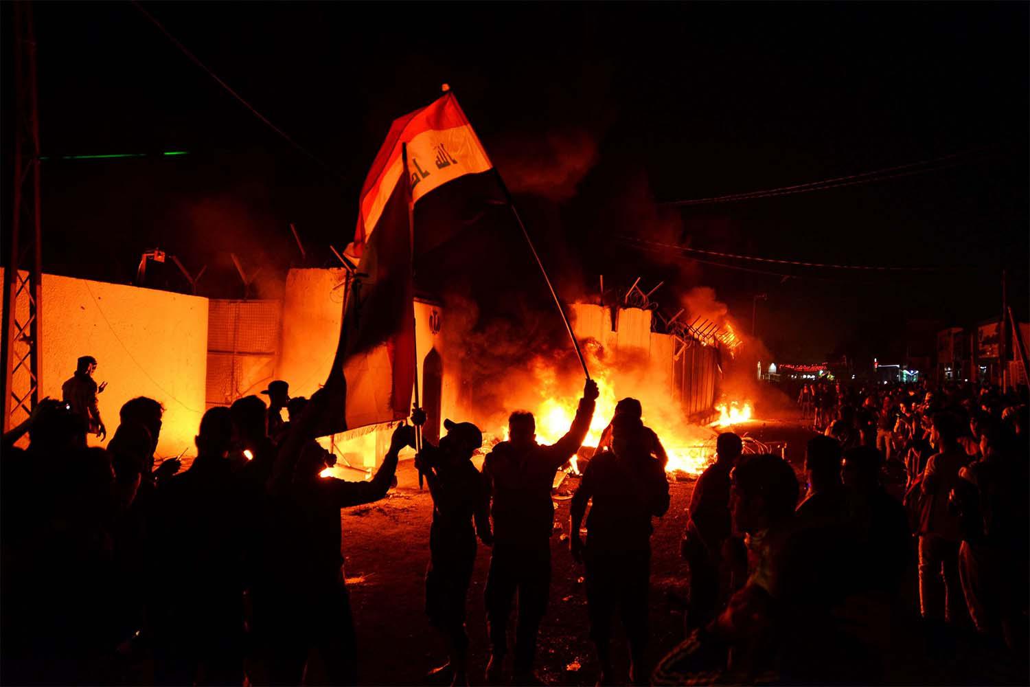 Iraqi demonstrators gather as flames start consuming Iran's consulate in the southern Iraqi Shiite holy city of Najaf 