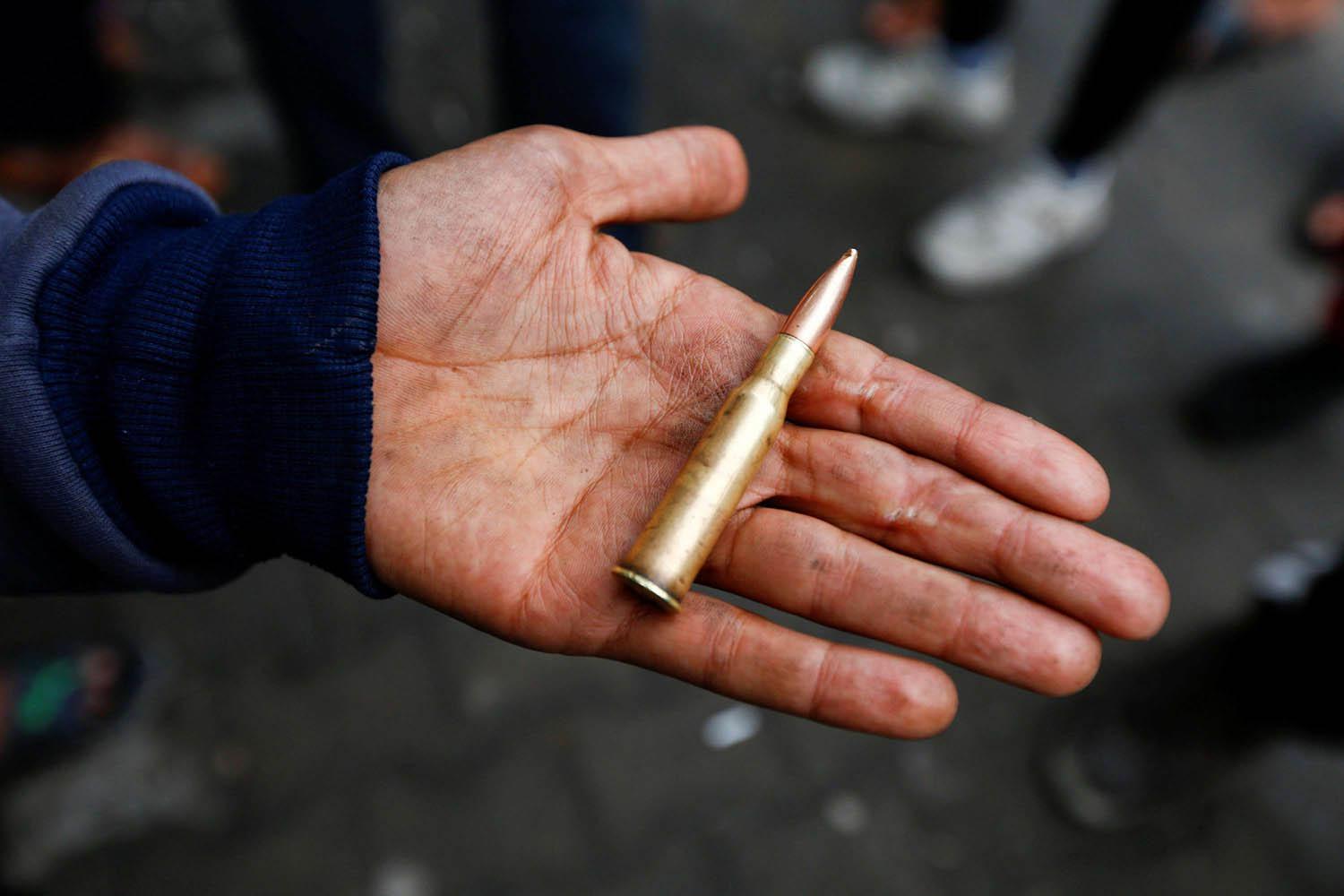عراقي يحمل رصاصة من رصاصات قناصة يستهدفون المحتجين في بغداد