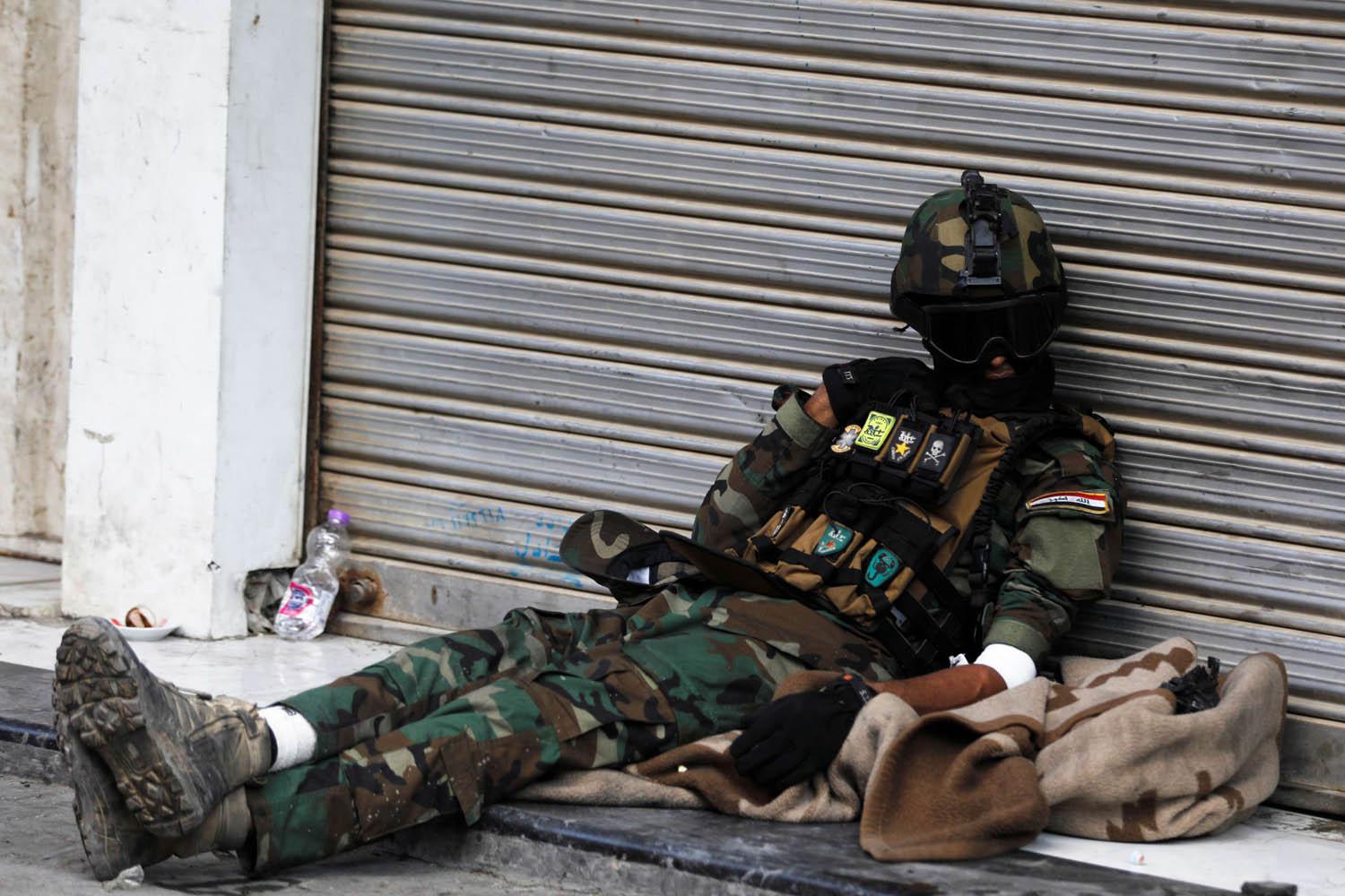 شرطي عراقي ينام في منطقة المواجهات وسط بغداد