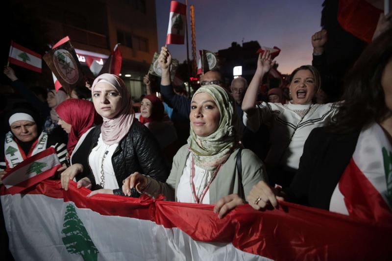 Lebanese protesters carry national flags as they take part in anti-government demonstrations in central Beirut