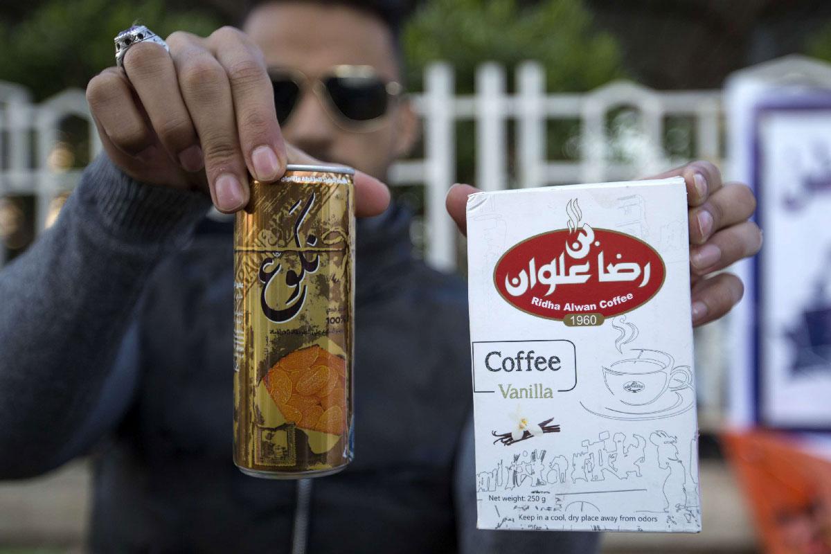 An Iraqi university student shows locally-made coffee and soft drink