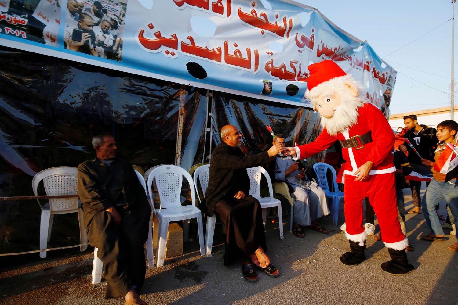 عراقي يرتدي بدلة بابا نويل يوزع الزهور على المحتجين في النجف