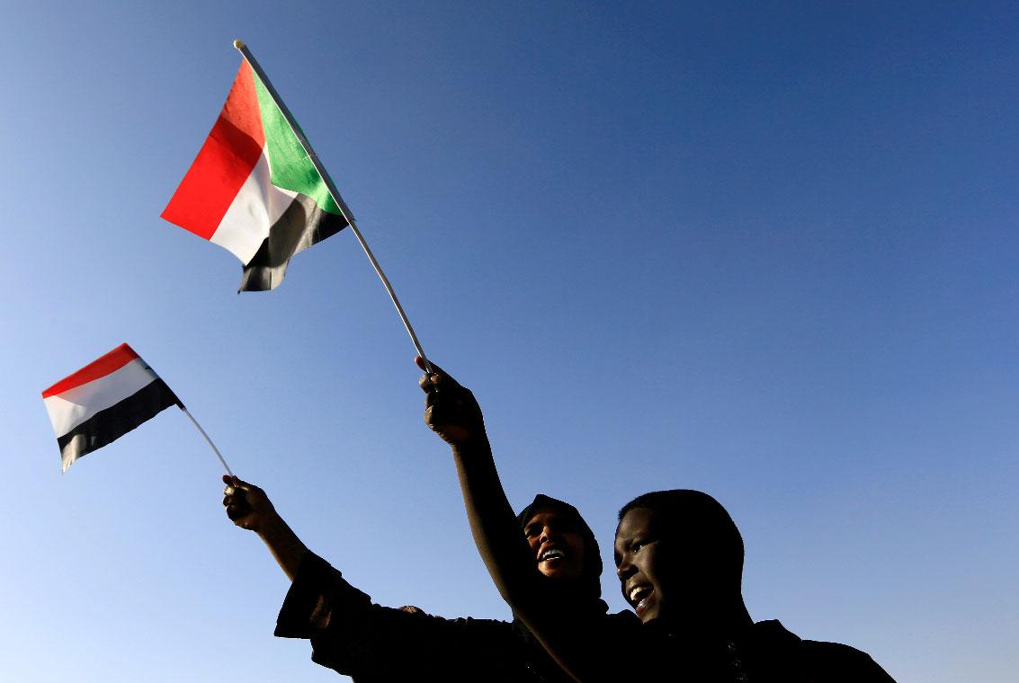 Sudanese civilians wave their national flag