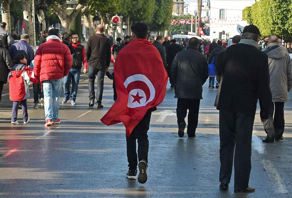 متظاهر تونسي يشارك الاحتفال بذكرى الثورة