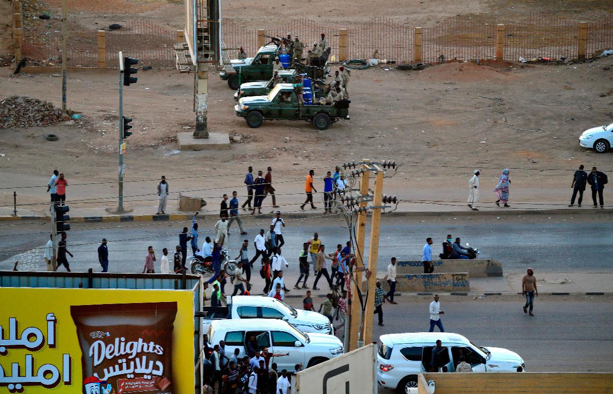Former members of Sudan's intelligence services (background) shoot bullets in the air in the Riyadh district of the capital Khartoum