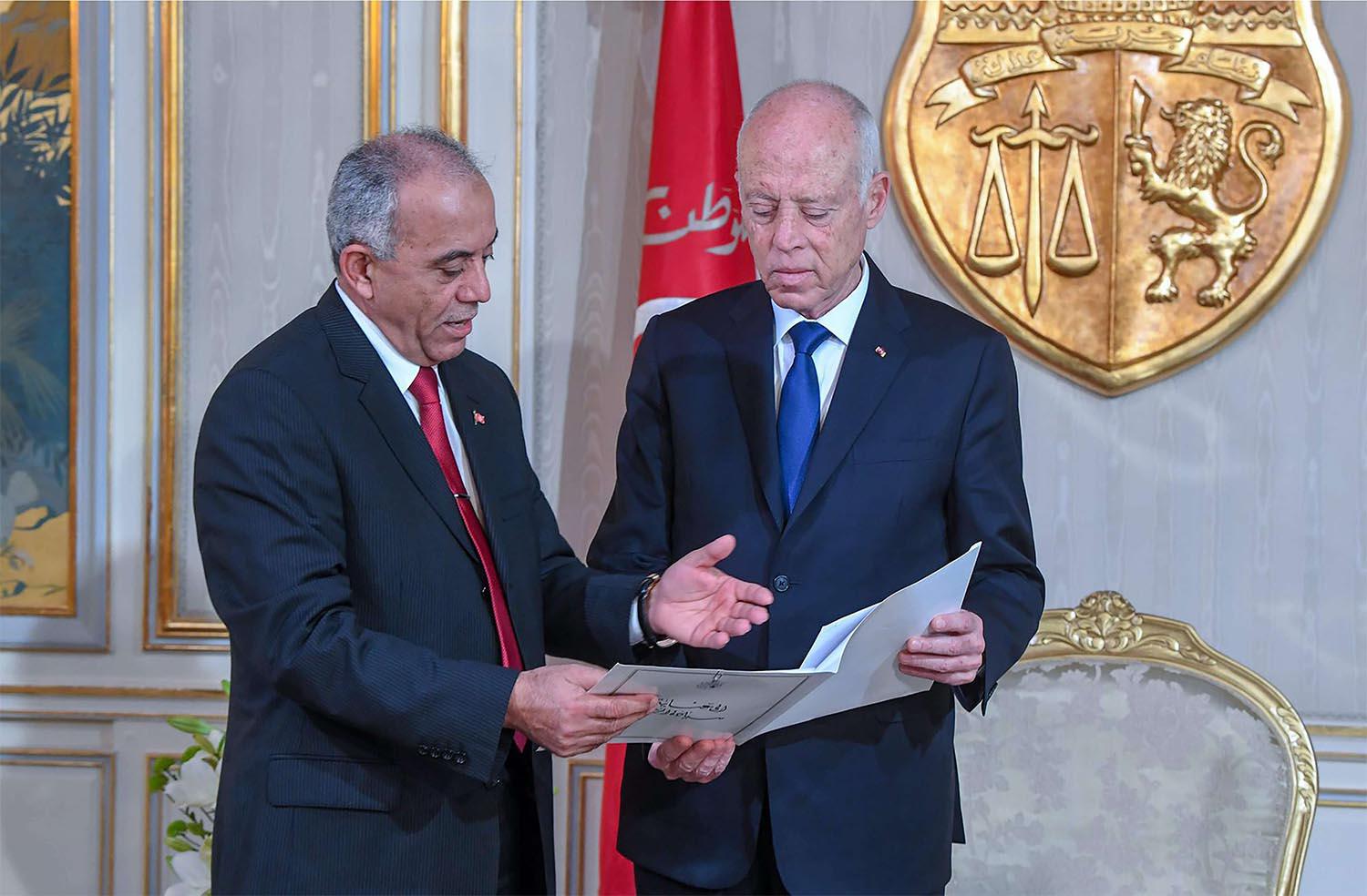 Tunisia's Prime Minister-designate Habib Jemli (L) submitting a proposed cabinet to President Kais Saied
