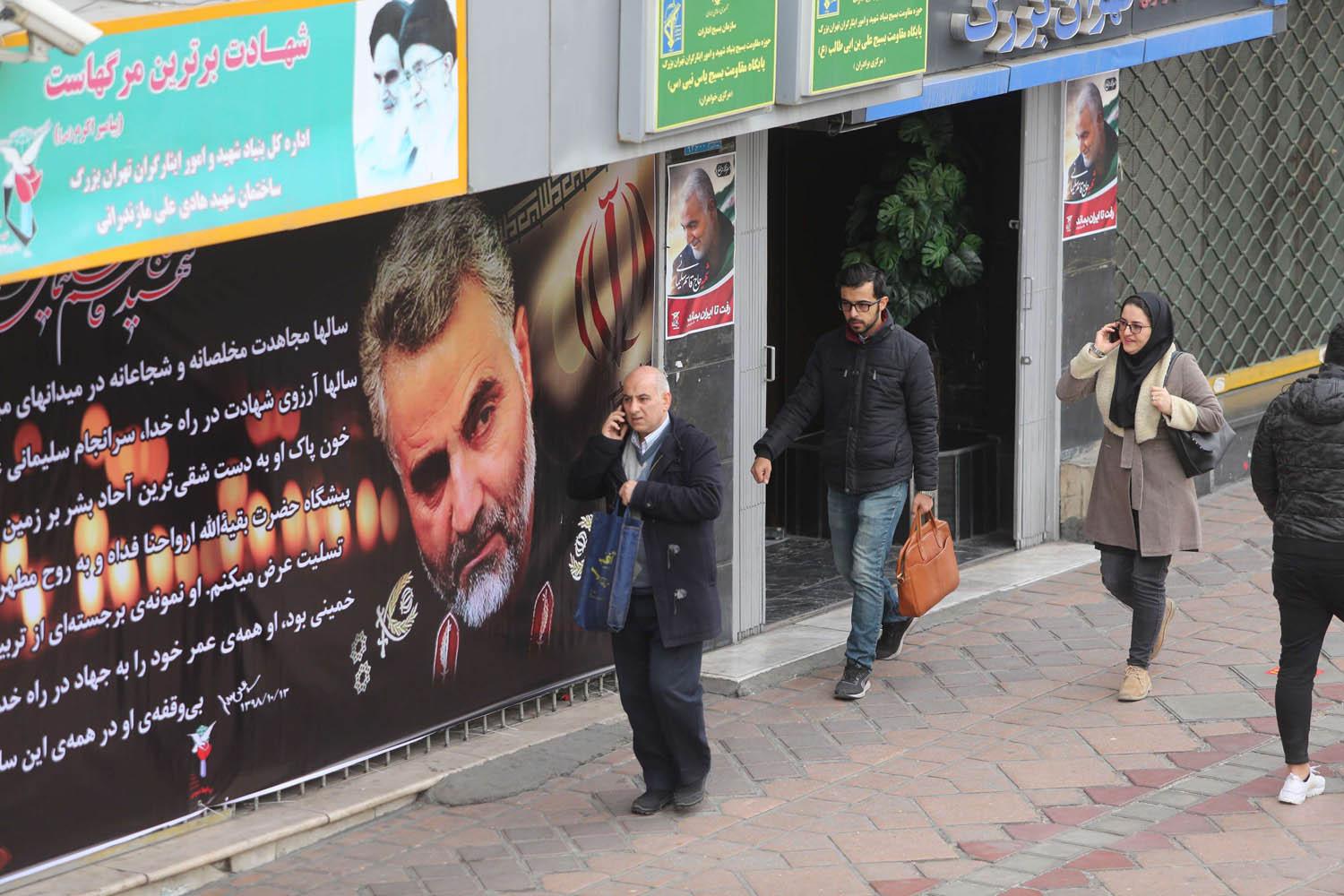 إيرانيون يمرون بجانب ملصقات عن سليماني تملأ وسط طهران