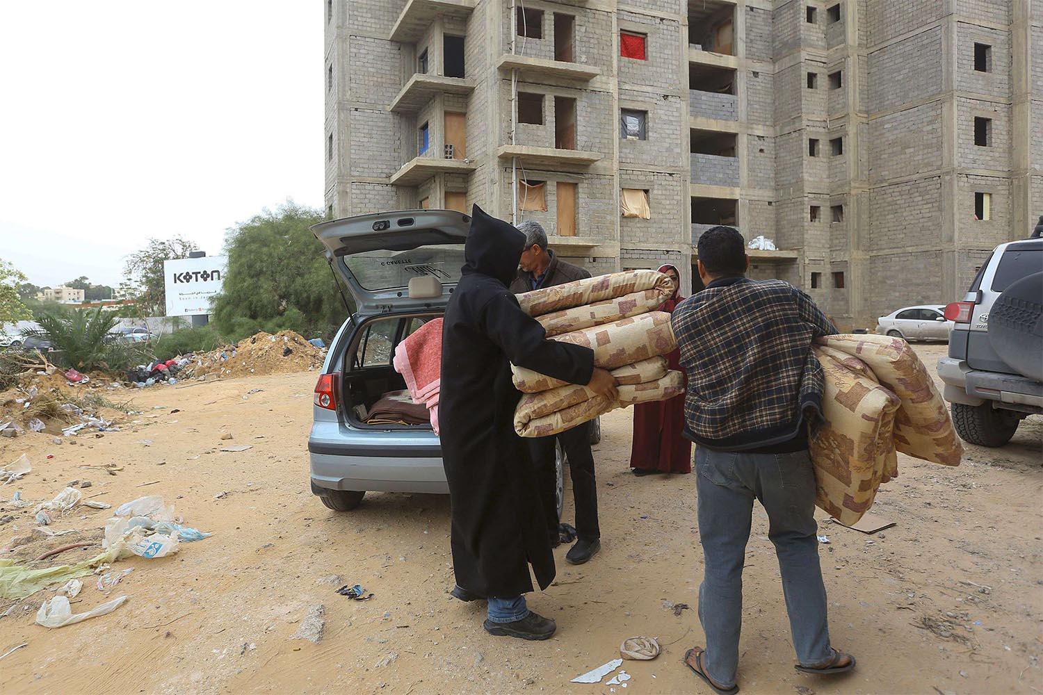 Displaced Libyans unload furniture in Tripoli