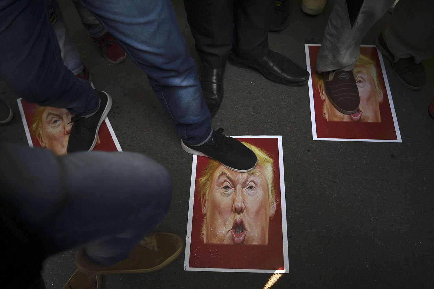 متظاهرون إيرانيون يدوسون صورا للرئيس الأميركي دونالد ترامب
