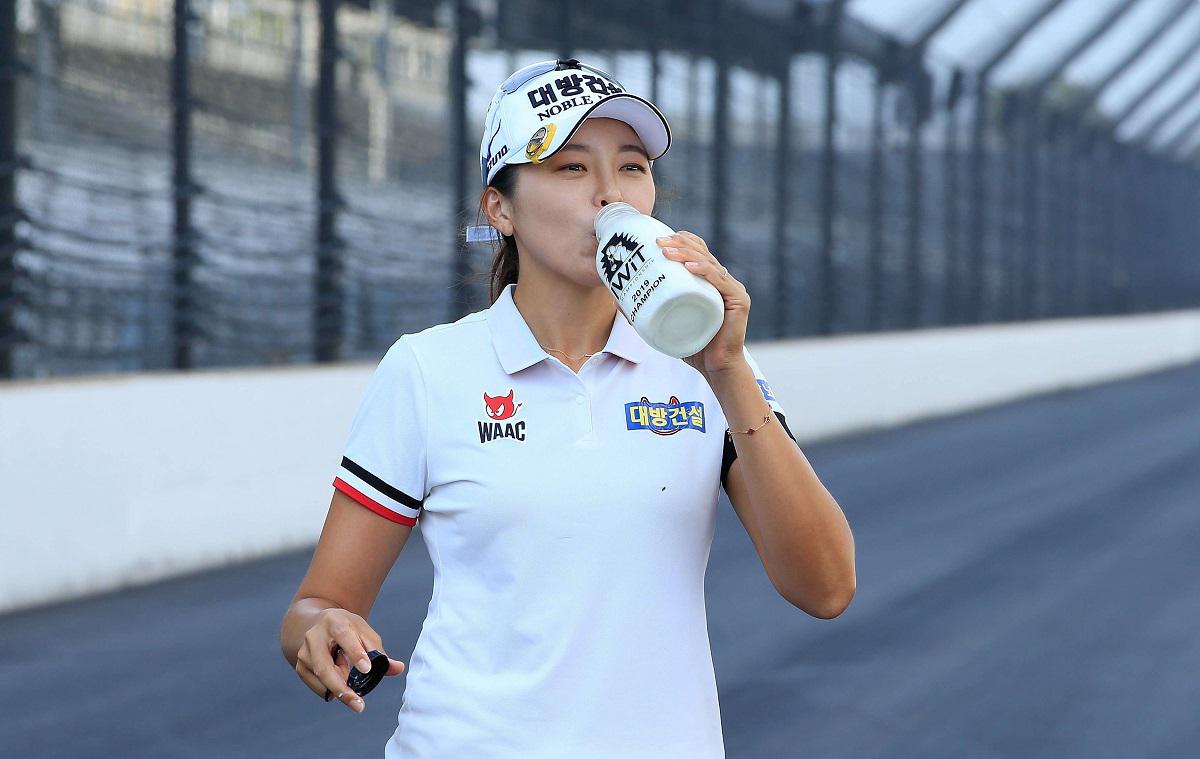 رياضية كورية تشرب الحليب في مضمار لسباق السيارات