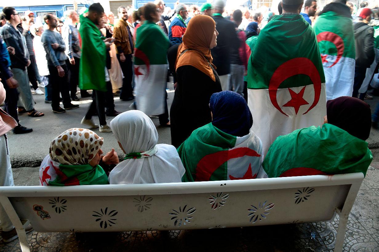 Algerians, clad in national flags, march in an anti-government demonstration in the capital Algiers