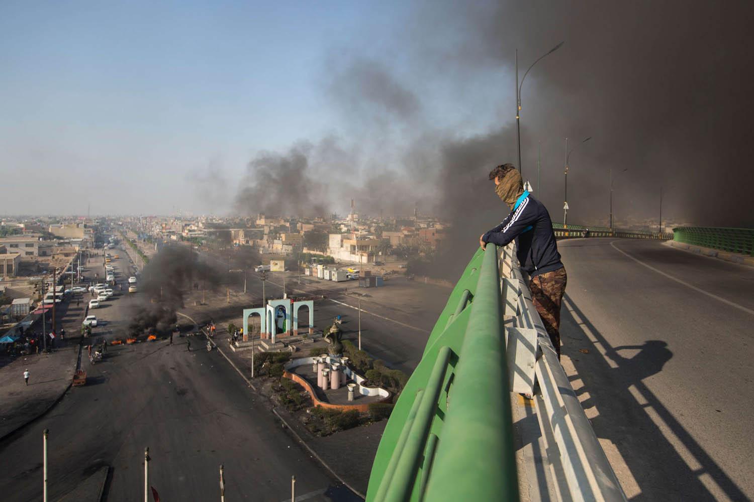 عراقي ينظر من جسر في البصرة