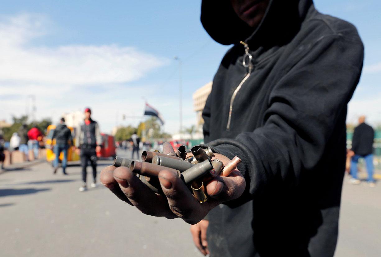 An Iraqi demonstrator shows the casings from bullets which were allegedly used by the Iraqi security forces