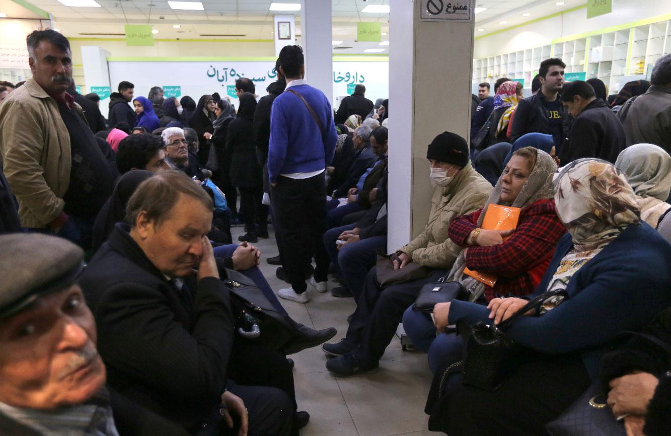 Iranians wait to get prescription drugs at the state-run "13 Aban" pharmacy in Tehran