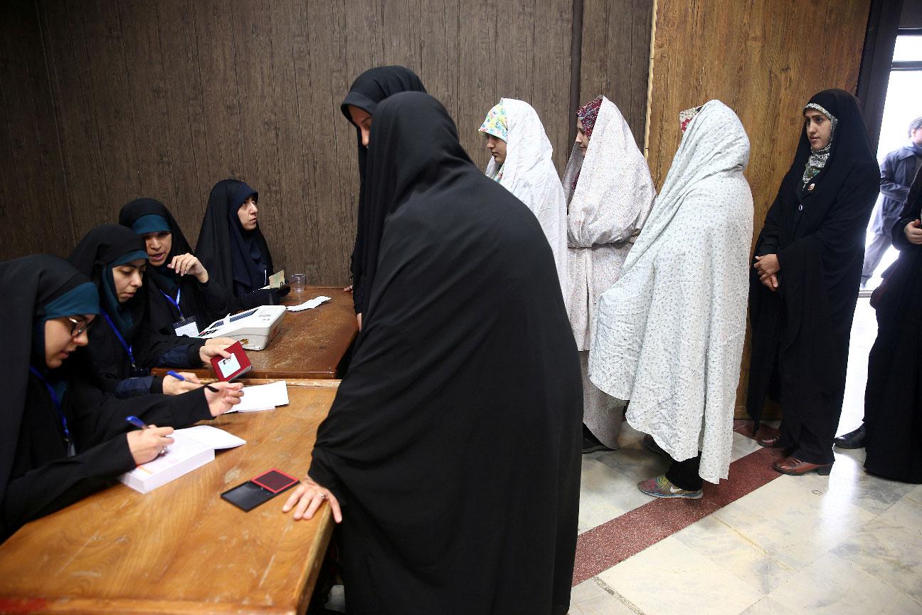 Women line up before they cast their vote during parliamentary elections at a polling station in Tehran